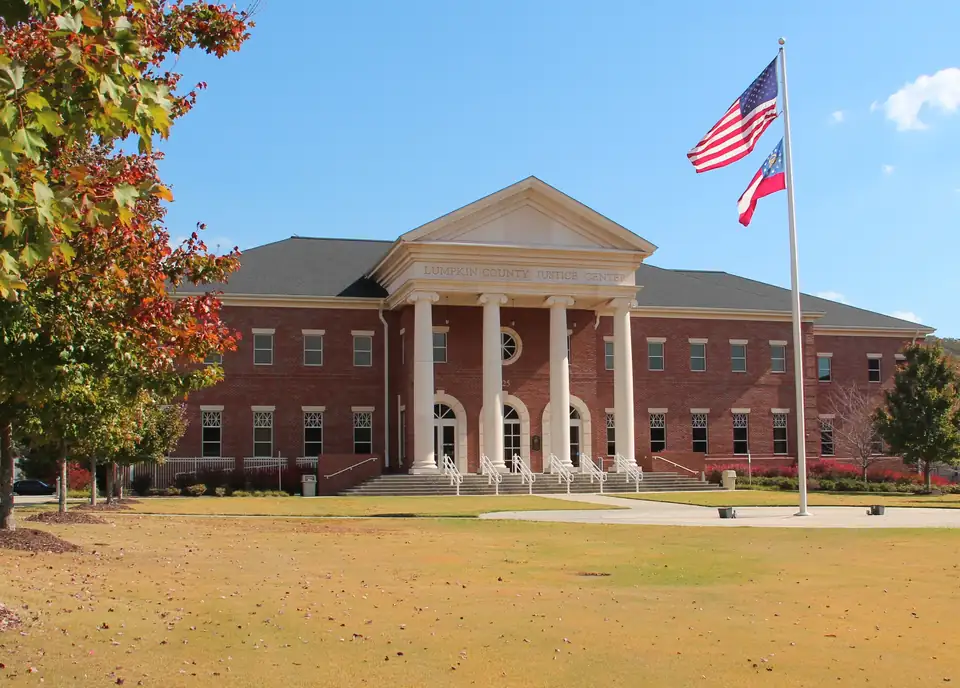 Lumpkin County Justice Center in Dahlonega, a red-brick courthouse with a white four-column portico and flags